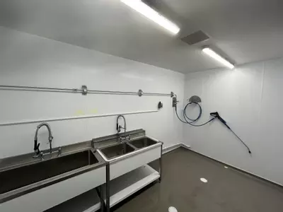 Stainless steel washroom with installed pipework, hose point and trigger gun connected to the wall-mounted pressure washer system in Nottingham